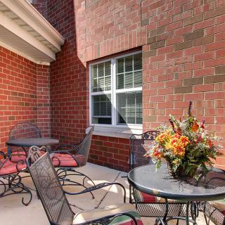 A cozy outdoor patio with wrought iron furniture and a decorative flower arrangement.