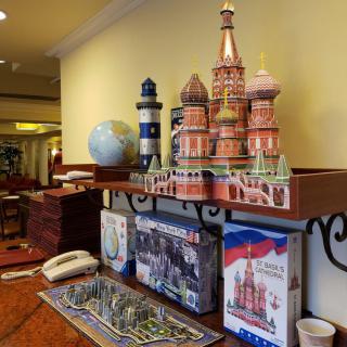 A shelf displaying various souvenirs including a model of St. Basil's Cathedral, a lighthouse, and a globe.