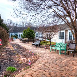 A serene courtyard garden with a paved pathway and colorful benches.