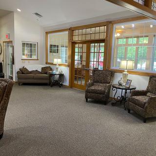 A cozy lobby area furnished with sofas and armchairs, featuring warm lighting and a welcoming atmosphere.