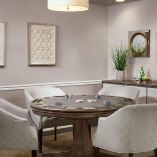A modern dining area with a round table and comfortable chairs, complemented by wall art and decorative plants.
