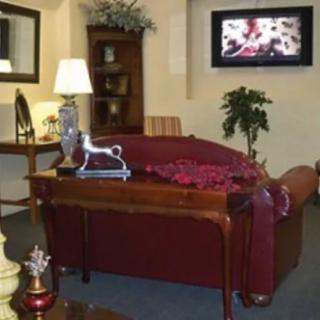 A cozy living room with a sofa, lamp, and television.