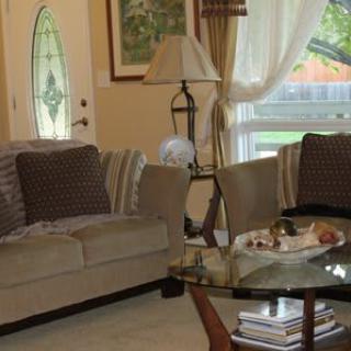 A cozy living room with a sofa, glass coffee table, and decorative elements.