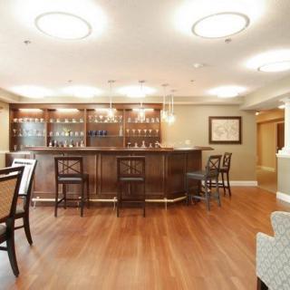 A cozy and elegant bar interior with wooden flooring and stylish furniture.