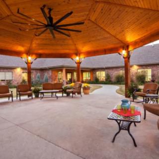 A cozy outdoor gazebo with warm lighting and comfortable seating.