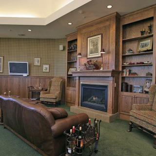 A cozy living room with a fireplace, bookshelves, and classic furniture.