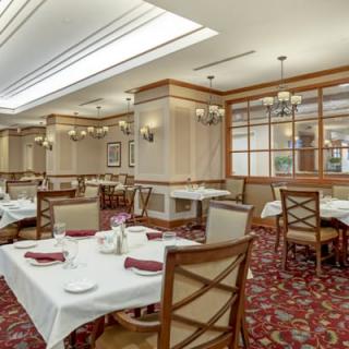 An elegant restaurant dining area with neatly arranged tables and chandeliers.