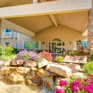 A beautifully landscaped garden with a waterfall in front of a house.
