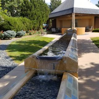 A serene water feature flows through a beautifully landscaped garden.
