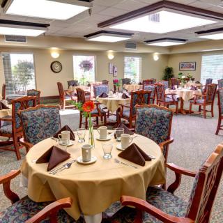 An elegantly set dining room with tables and chairs arranged for guests.