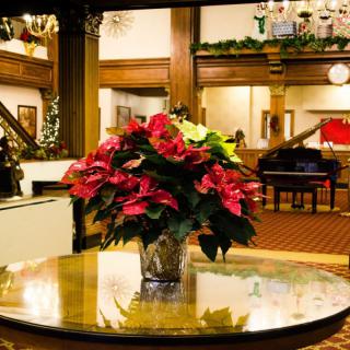 A festive poinsettia arrangement adorns the center of a hotel lobby, adding holiday warmth to the elegant interior.