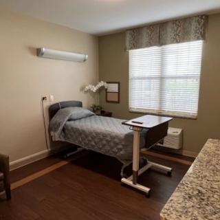 A simple hospital room with a single bed and medical equipment.