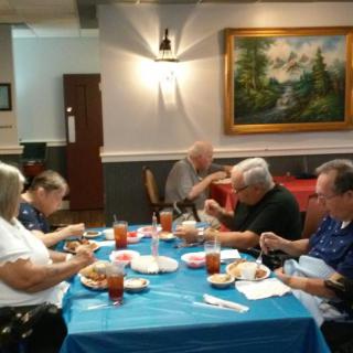 A group of people enjoying a meal together in a restaurant setting.