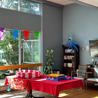 A vibrant living room setup decorated for a party, featuring colorful banners and a cozy atmosphere.