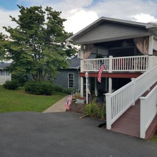 A charming house with a welcoming porch and a neatly maintained front yard.