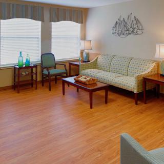 A cozy living room with a sofa, chairs, and a wooden coffee table on a hardwood floor.