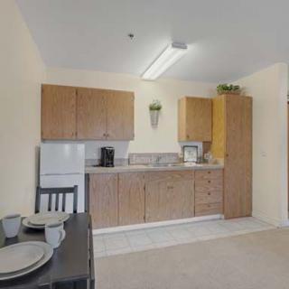 A compact kitchen area with wooden cabinets and a small dining table.