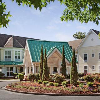 A picturesque residential building with a green roof and well-maintained landscaping.