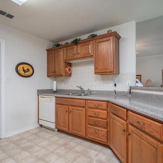 A cozy kitchen with wooden cabinets and a dishwasher under the counter.