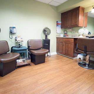 A cozy waiting area in a hair salon with comfortable seating and a wooden floor.