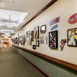 A hallway adorned with a variety of framed pictures and decorations on the walls.