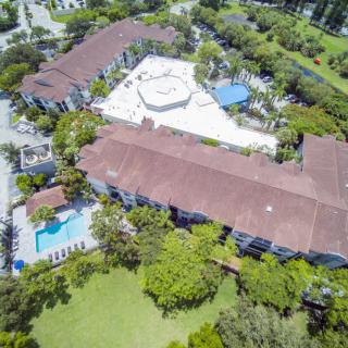 Aerial view of a residential complex with a swimming pool and lush greenery.