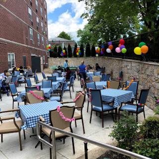 A vibrant outdoor seating area decorated with colorful balloons, ready for a community gathering.