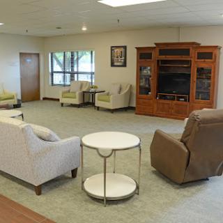 A cozy lounge area featuring comfortable seating and a television unit.
