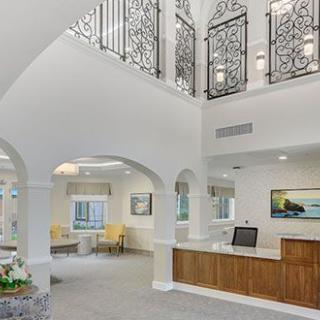 A modern lobby interior with a reception desk and elegant architectural details.