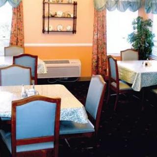 An empty restaurant dining area with neatly arranged tables and chairs.
