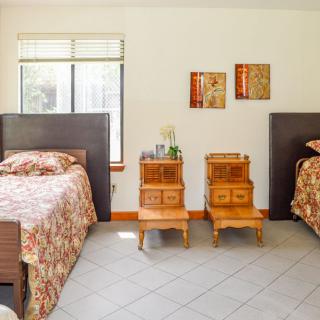 A tidy bedroom with two beds and wooden nightstands.