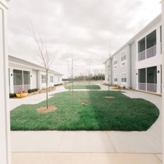 A well-maintained courtyard with a grassy lawn and surrounding buildings.