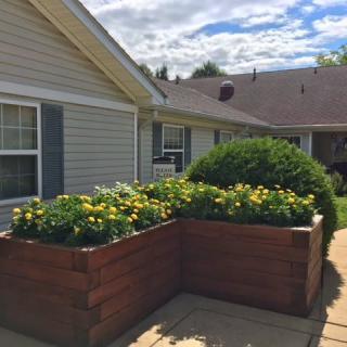 Raised flower beds outside a residential home on a sunny day.