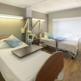 A hospital room with two patient beds and medical equipment.