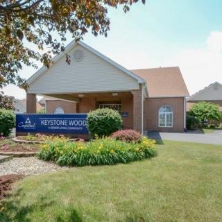 Exterior view of a residential building with a well-maintained garden and signage.