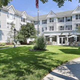 A residential building with a well-maintained lawn and garden area.