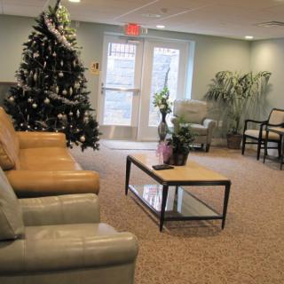 A cozy living room decorated with a Christmas tree and comfortable seating.