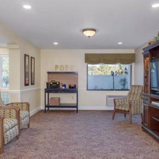 A cozy living room with seating, a television, and warm decor.