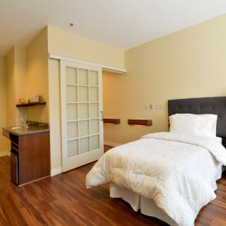 A minimalist bedroom with a single bed and modern decor.