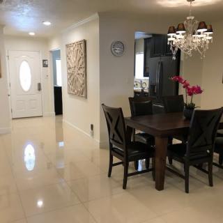 A modern dining room with elegant furnishings, including a chandelier and artwork on the walls.
