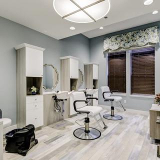 A modern hair salon interior with stylish chairs and mirrors.
