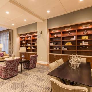 A cozy living room with modern decor featuring bookshelves and a seating area.