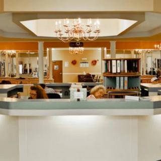 A modern reception desk in a spacious office with elegant chandeliers.
