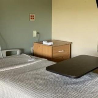 An empty hospital room with a bed and medical equipment.