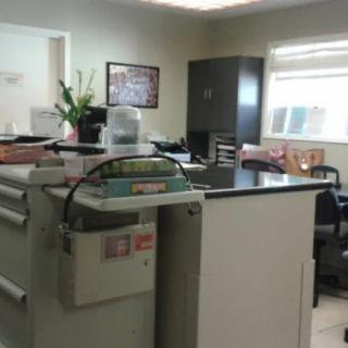 A tidy office space with desks, chairs, and storage cabinets.