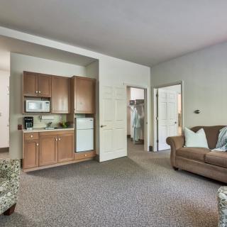 A modern and cozy apartment living space featuring a small kitchenette and a comfortable seating area.