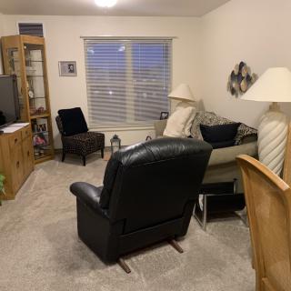 A cozy living room with various seating options and a television.