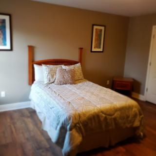 A cozy and minimalist bedroom with a neatly made bed and simple decor.