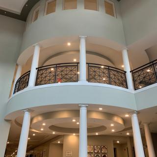A luxurious interior featuring grand columns, a decorative balcony, and elegant lighting.