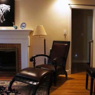 A cozy living room featuring a fireplace and leather seating, accented by artwork on the wall.